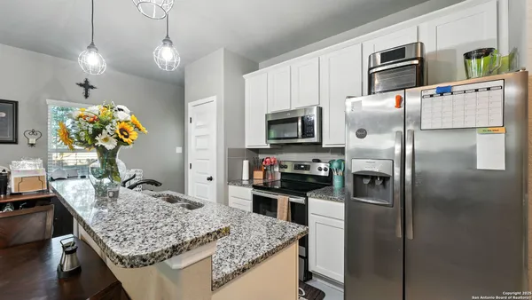 a kitchen with stainless steel appliances granite countertop a sink refrigerator and microwave