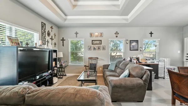 a living room with furniture a flat screen tv and a large window