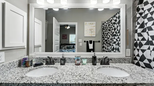 a bathroom with a granite countertop sink and a mirror