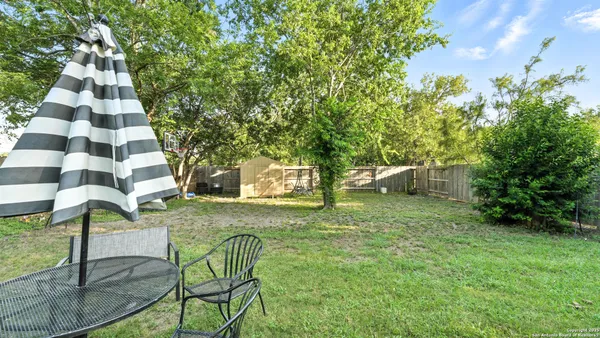a backyard of a house with table and chairs