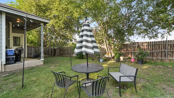 a view of a chairs and table in backyard of the house