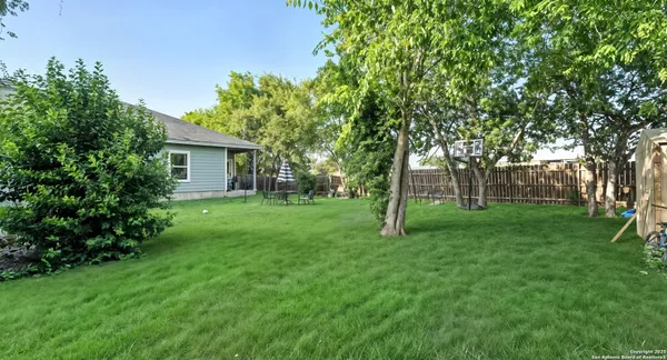 a view of a house with backyard and a tree