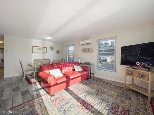 a living room with furniture a flat screen tv and a window