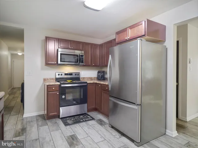 a kitchen with stainless steel appliances granite countertop a refrigerator and a stove
