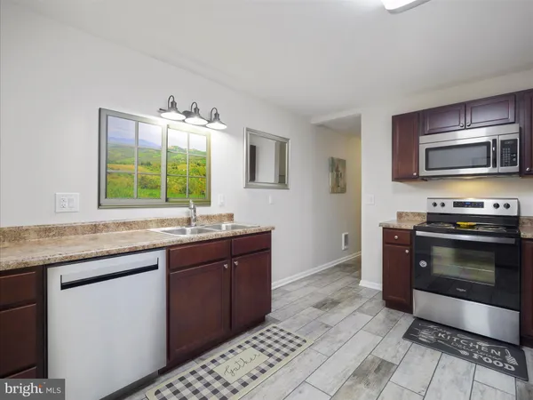 a kitchen with stainless steel appliances granite countertop a stove a sink and a microwave