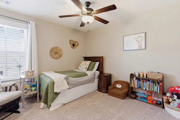 a bedroom with bed and a chandelier fan