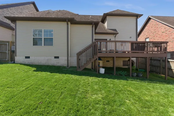 a view of house with backyard and deck