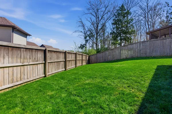 a view of backyard with wooden fence