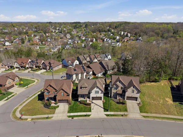 an aerial view of a residential houses with outdoor space and parking