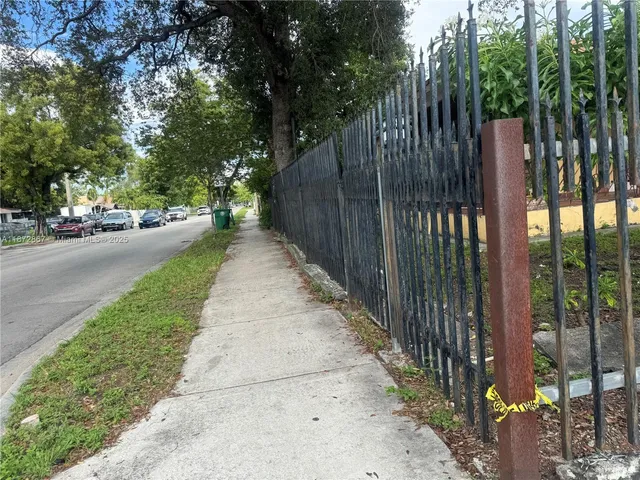 a view of a pathway of a park with large trees