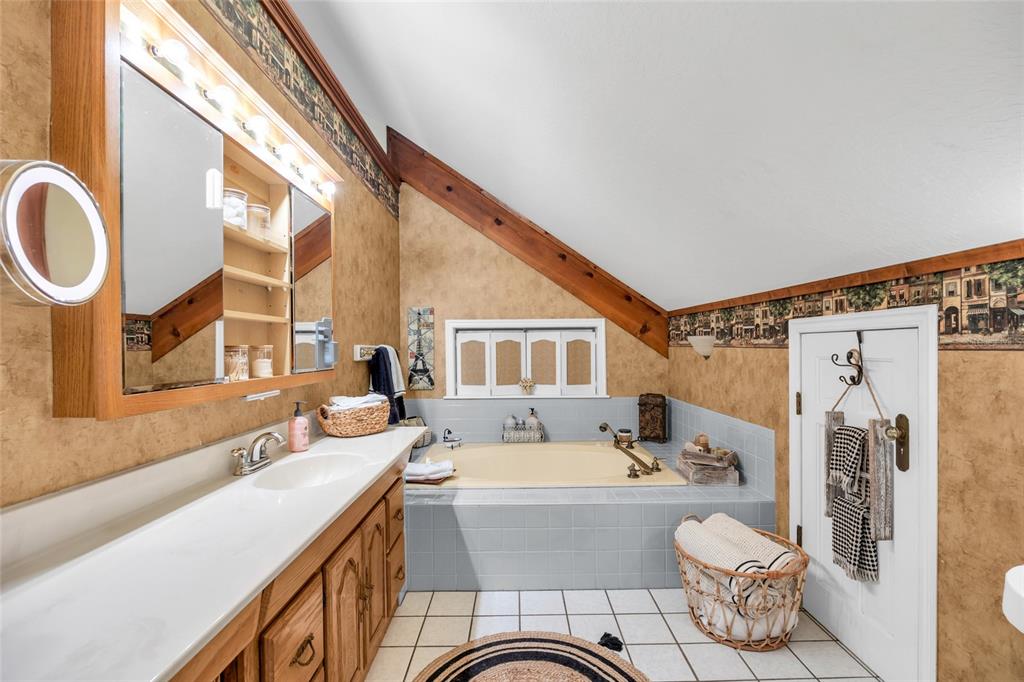 1217 Edgewood Ranch Road Orlando, FL 32835 - Photo 43 of 91 a bathroom with a sink a mirror and a bathtub