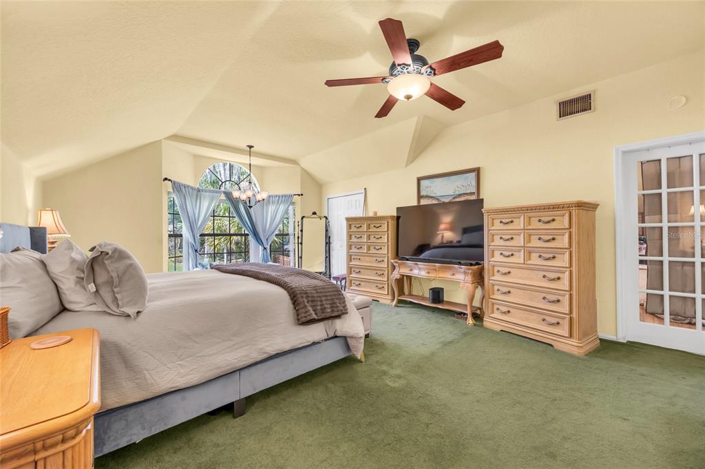 1217 Edgewood Ranch Road Orlando, FL 32835 - Photo 45 of 91 a bedroom with a bed a dresser and a flat screen tv