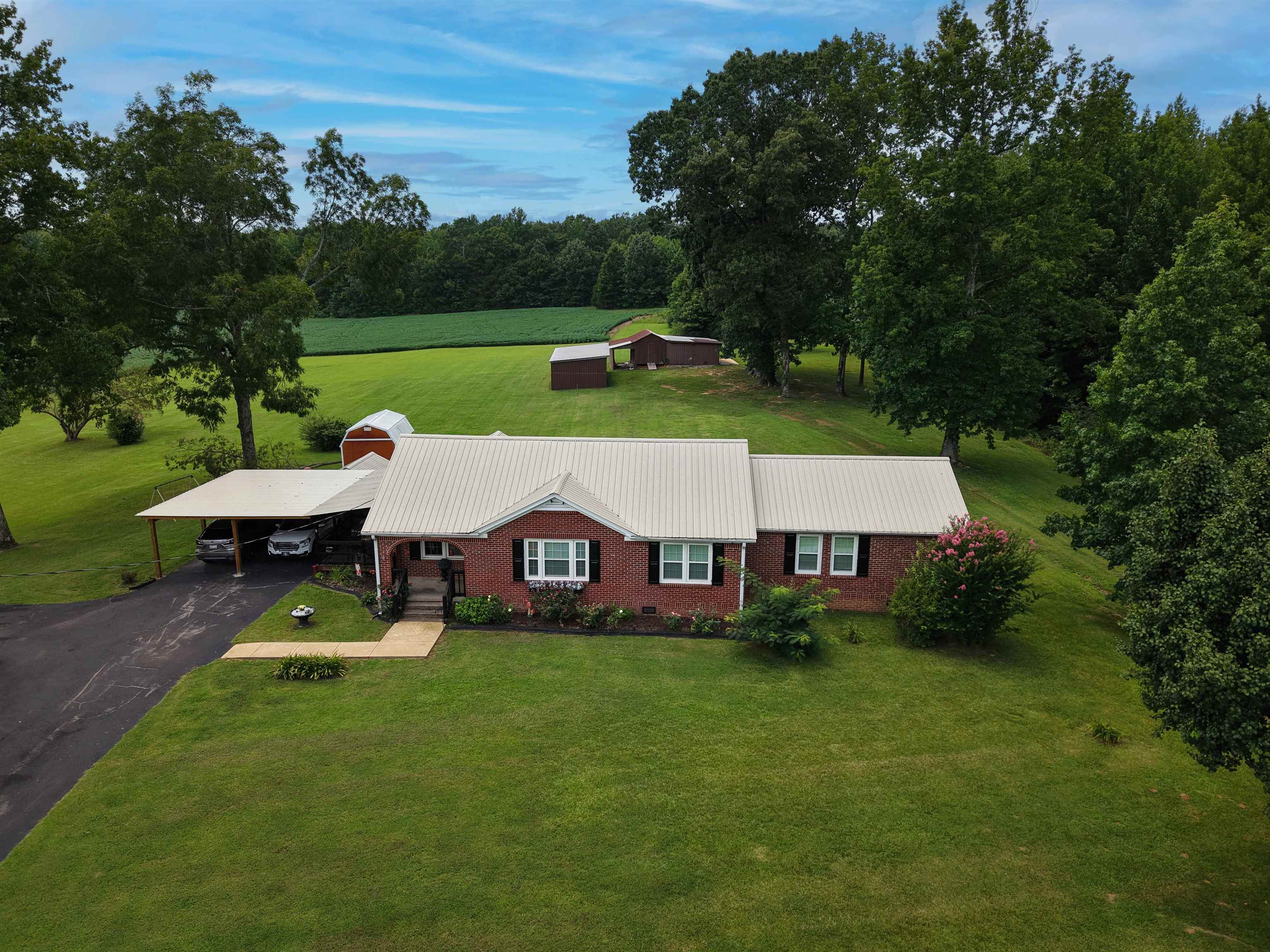 2665 Powell Chapel Road Middleton, TN 38052 - Photo 2 of 36 Brick ranch-style home featuring a metal roof, attached carport, and a paved driveway