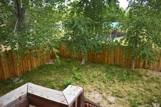 3327 East Windhover Road Eagle Mountain, UT 84005 - Photo 32 of 38 Private backyard space featuring a wood privacy fence and mature trees
