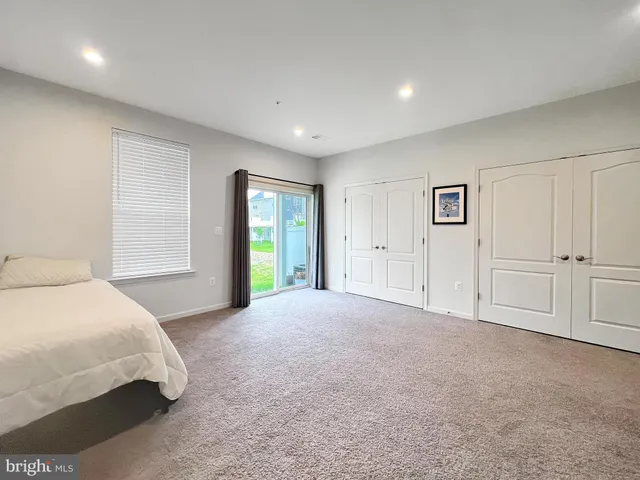 a spacious bedroom with a large bed closet and window