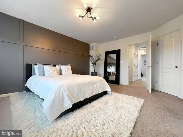 a bedroom with a large bed and a chandelier