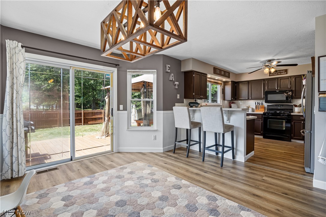 684 Guilford Road Vermilion, OH 44089 - Photo 11 of 37 Kitchen featuring light hardwood / wood-style floors, black appliances, kitchen peninsula, and plenty of natural light