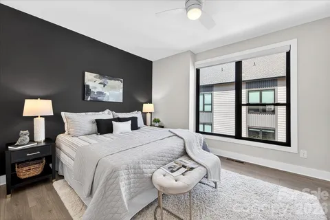 a spacious bedroom with a bed a wall painting and a window