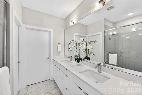 a bathroom with double vanity sink and a mirror