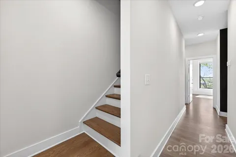 a view of a hallway with wooden floor and entryway