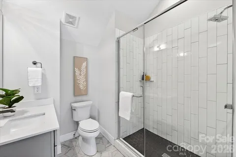 a bathroom with a shower a toilet and sink
