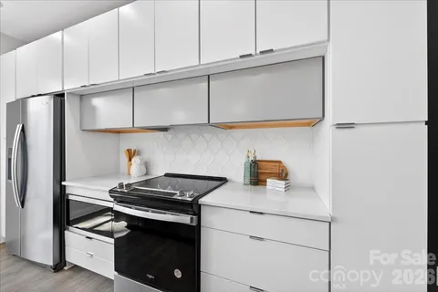 a kitchen with stainless steel appliances granite countertop a stove a refrigerator and a cabinets