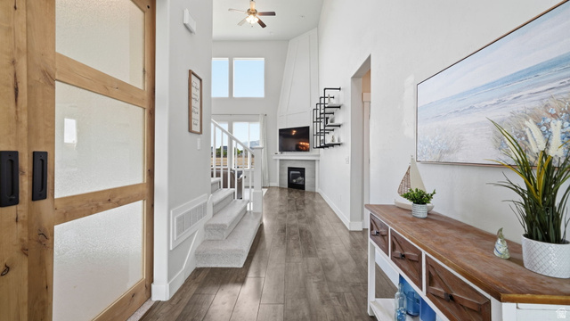 111 East Silver Oak Road Vineyard, UT 84059 - Photo 7 of 50 Spacious entryway with wood-finish flooring, a contemporary barn door featuring frosted glass panels, and a staircase with carpeted treads