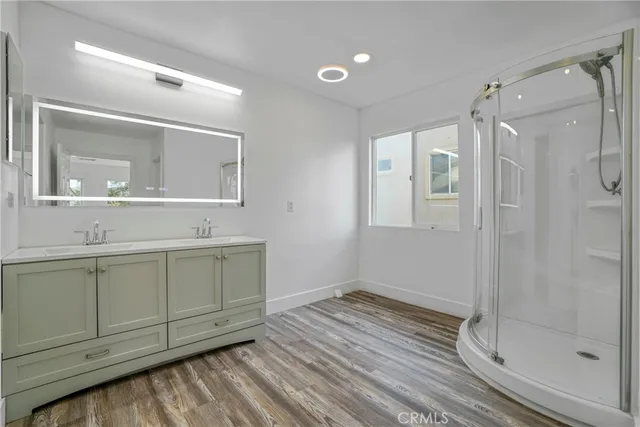 a bathroom with a shower sink and mirror