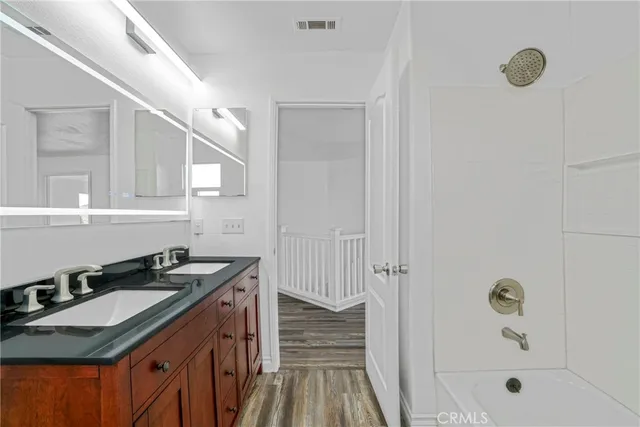 a bathroom with a granite countertop sink a mirror and shower
