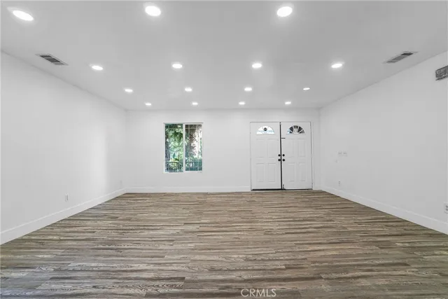 a view of empty room with wooden floor