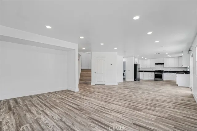 a view of an empty room with wooden floor