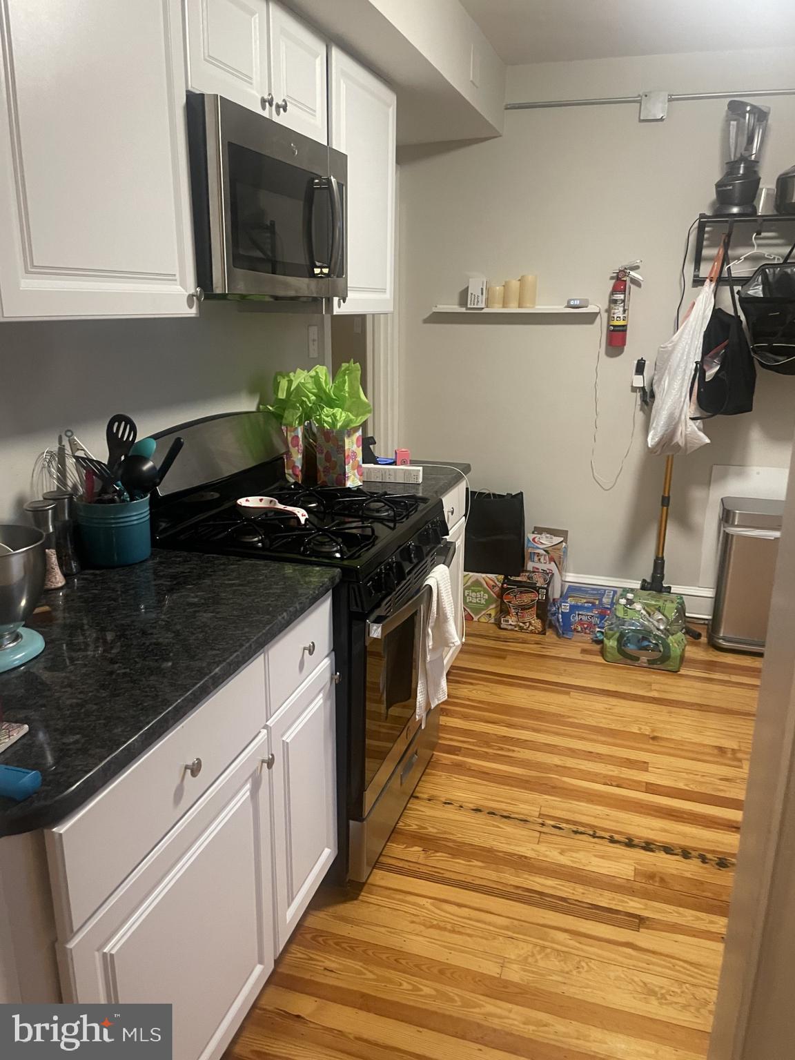 127 State Street, Unit 2 Kennett Square, PA 19348 - Photo 5 of 11 a kitchen with stainless steel appliances kitchen island granite countertop a sink stove and microwave