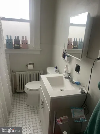 a bathroom with a sink a toilet and a window