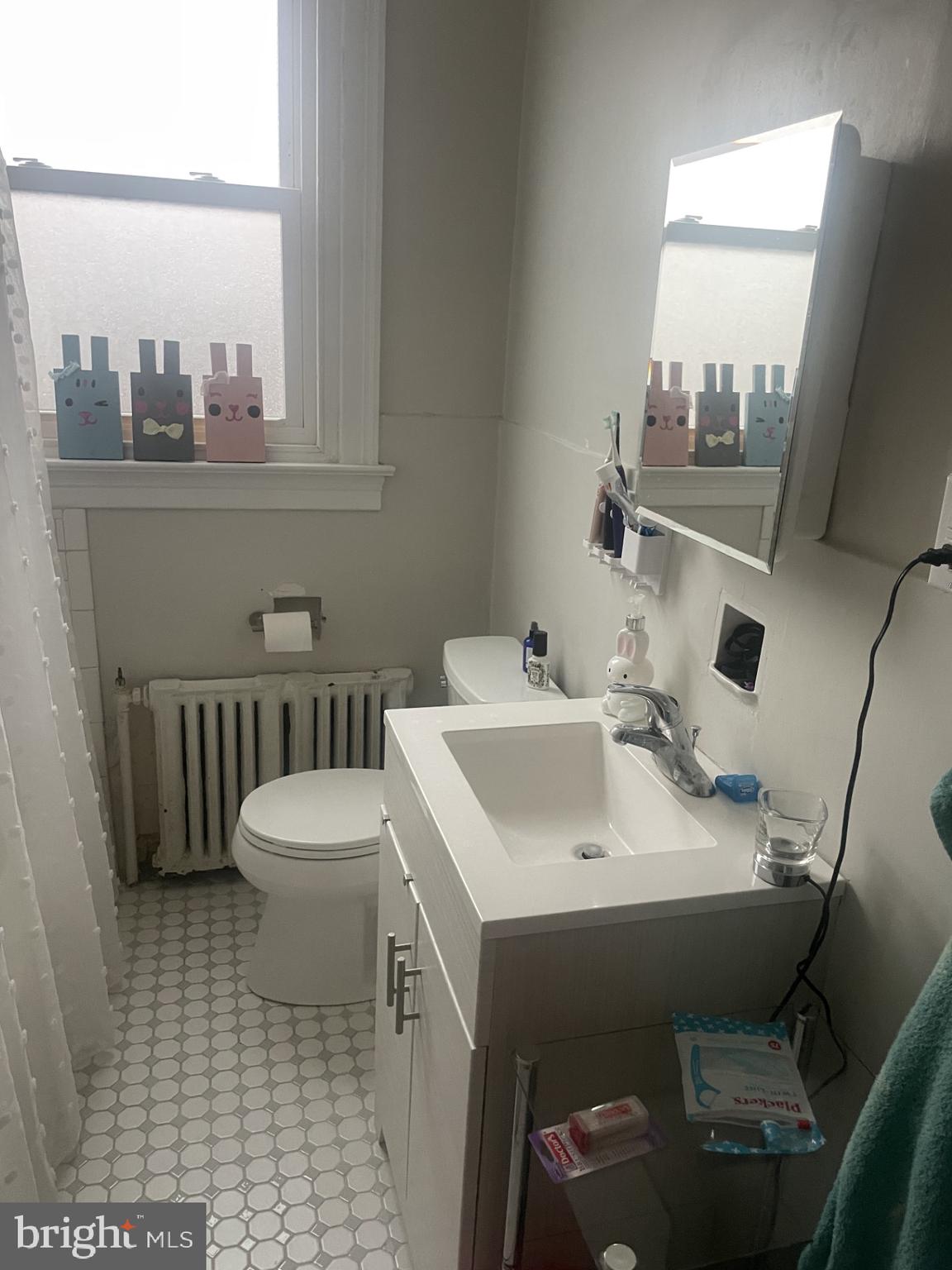 127 State Street, Unit 2 Kennett Square, PA 19348 - Photo 7 of 11 a bathroom with a sink a toilet and a window