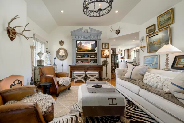 a living room with furniture a flat screen tv and a chandelier