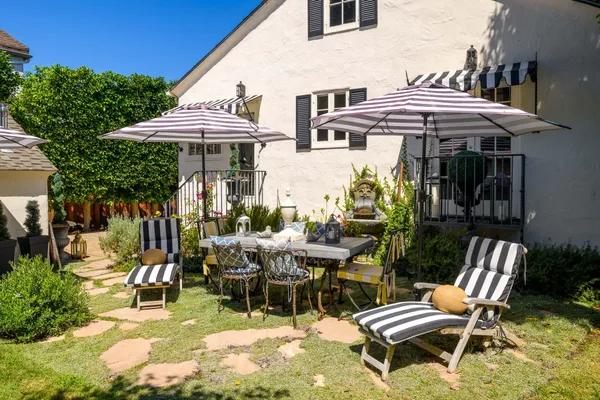 a view of a patio with table and chairs under an umbrella