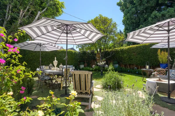 a view of a chairs and tables in patio with a barbeque