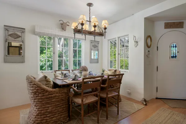 a dining room with furniture a chandelier and wooden floor