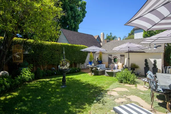 a view of a patio with table and chairs under an umbrella