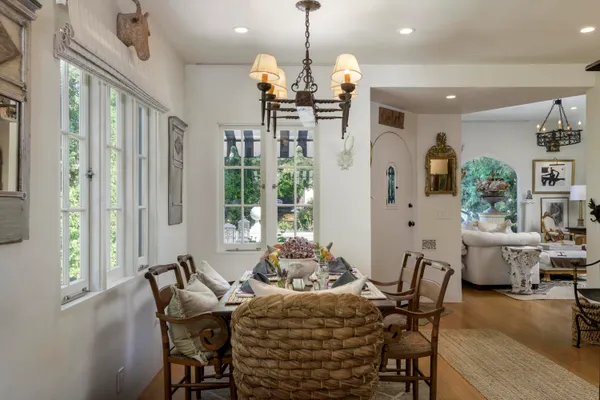 a dining room filled chandelier and wooden floor