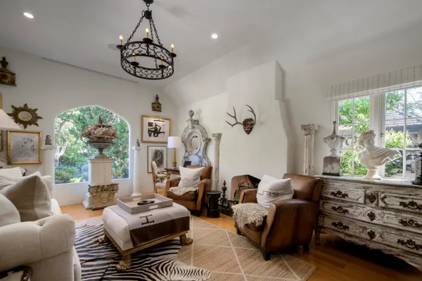 a living room with furniture chandelier and a large window