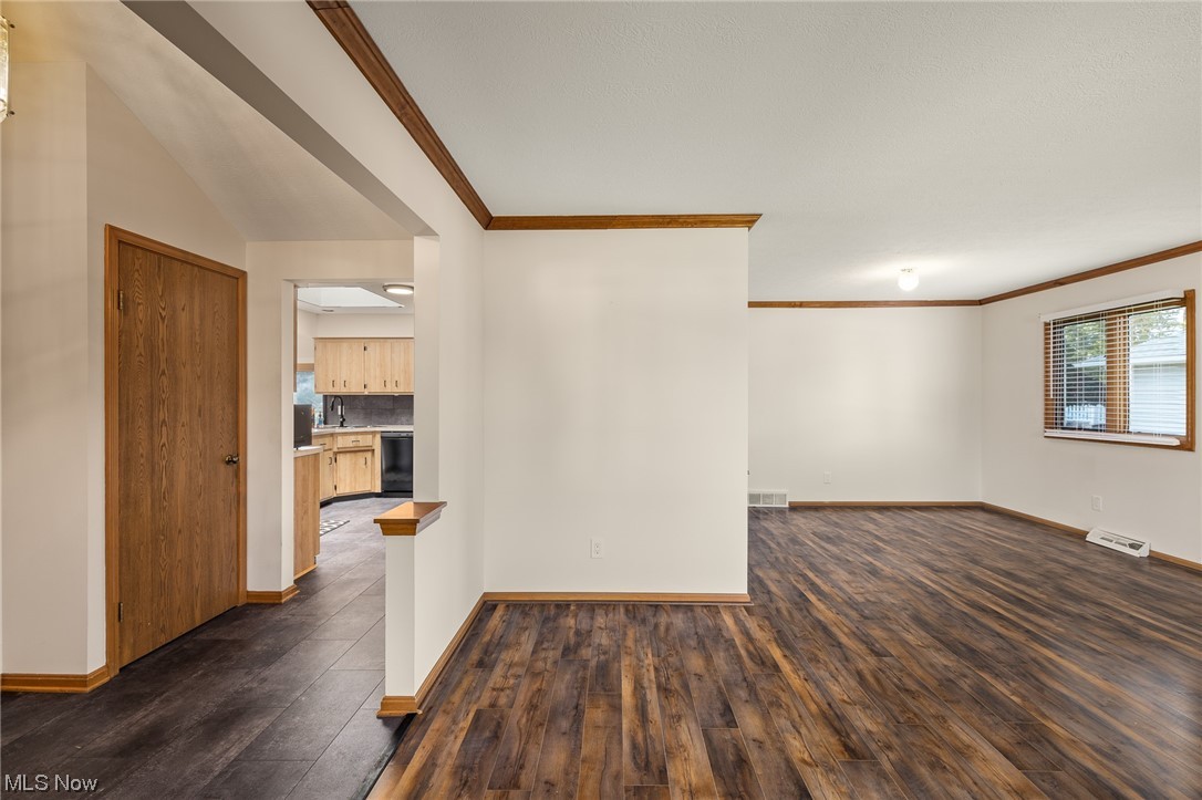 14495 Sheldon Road Cleveland, OH 44130 - Photo 5 of 27 Spare room featuring dark hardwood / wood-style flooring, crown molding, and lofted ceiling