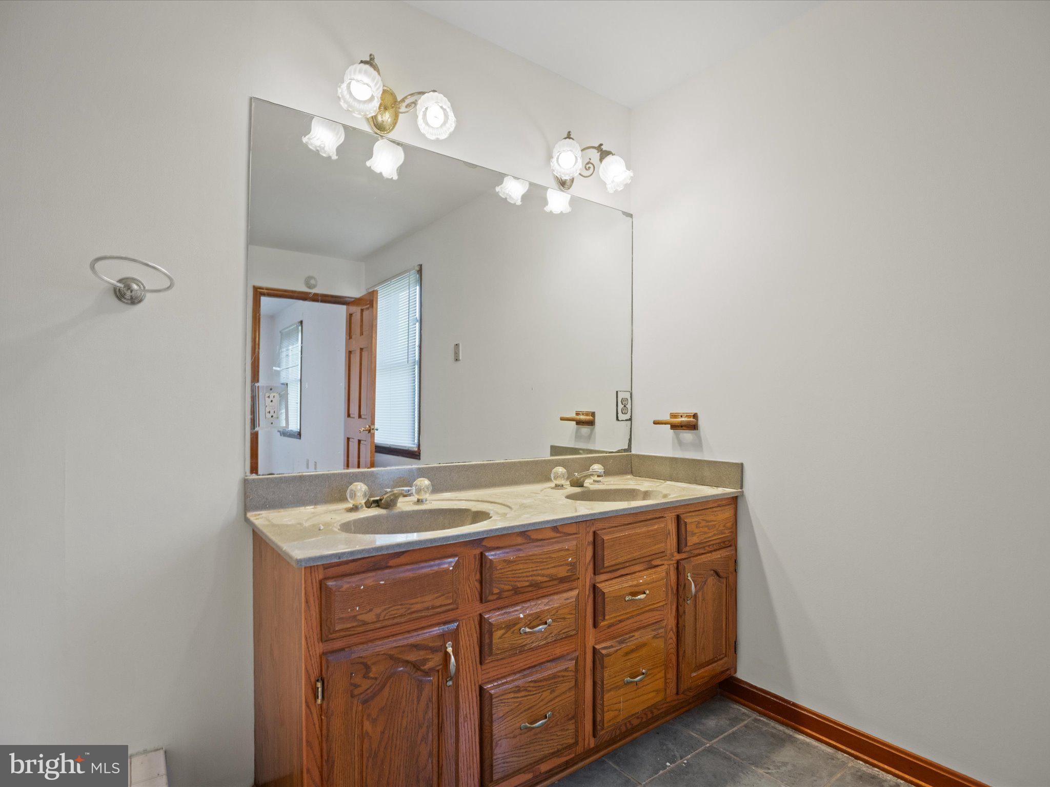4340 Huntingtown Road Huntingtown, MD 20639 - Photo 32 of 42 a bathroom with a granite countertop sink a light fixture and a mirror