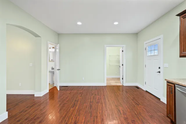 a view of wooden floor in an empty room with a window
