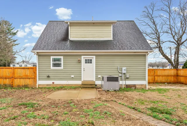 a view of a house with backyard and a tree
