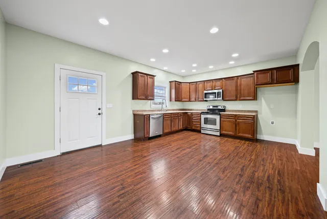 a view of kitchen with wooden floor electronic appliances and window