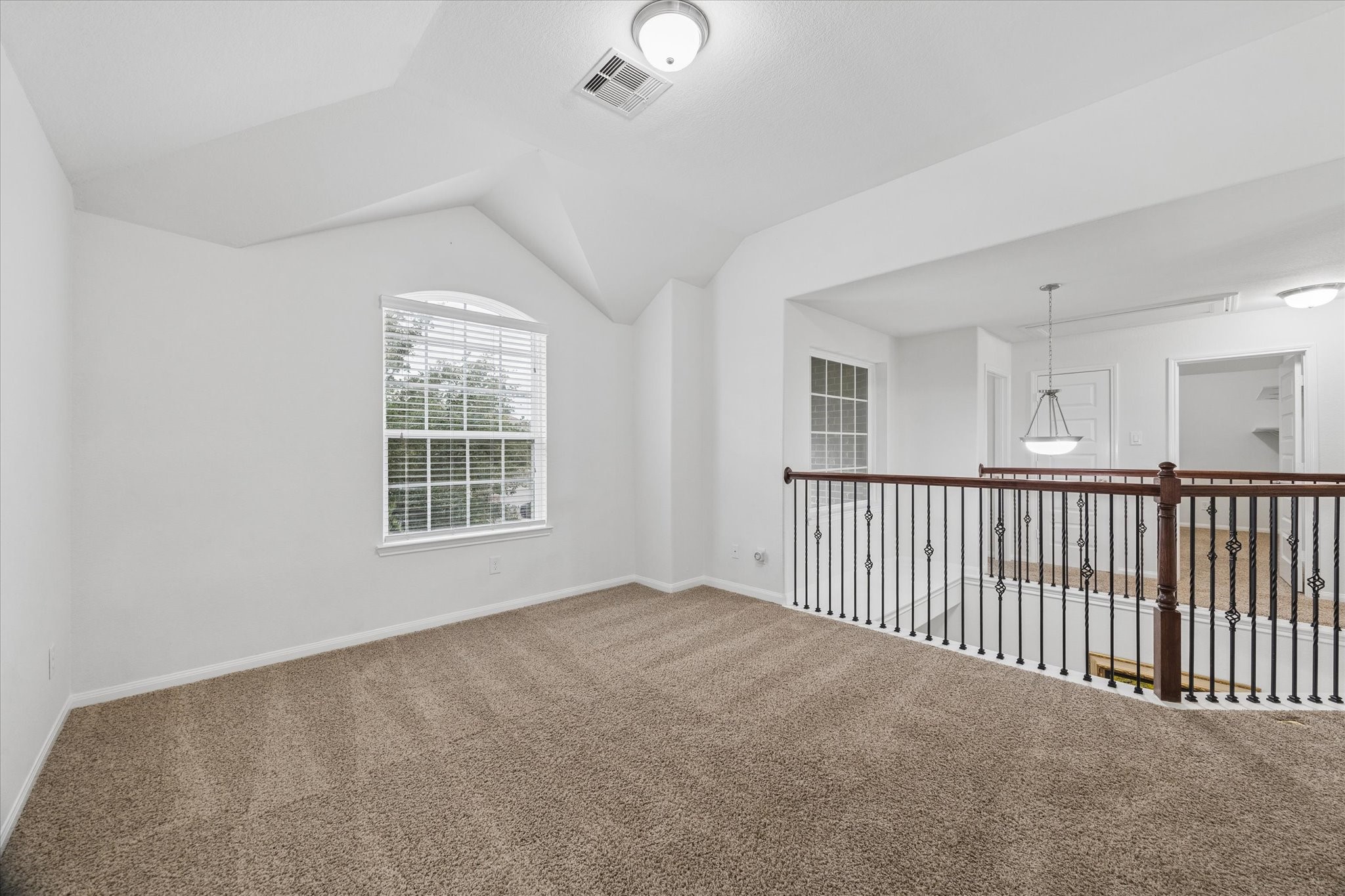 7015 Riata Hills Lane Spring, TX 77379 - Photo 21 of 33 This versatile upper-level loft can be used as a game room, home office, or additional living space. An elegant iron railing maintains a visual connection to the main level, while large windows fill the area with natural light. Light tones enhance the sense of openness and brightness.