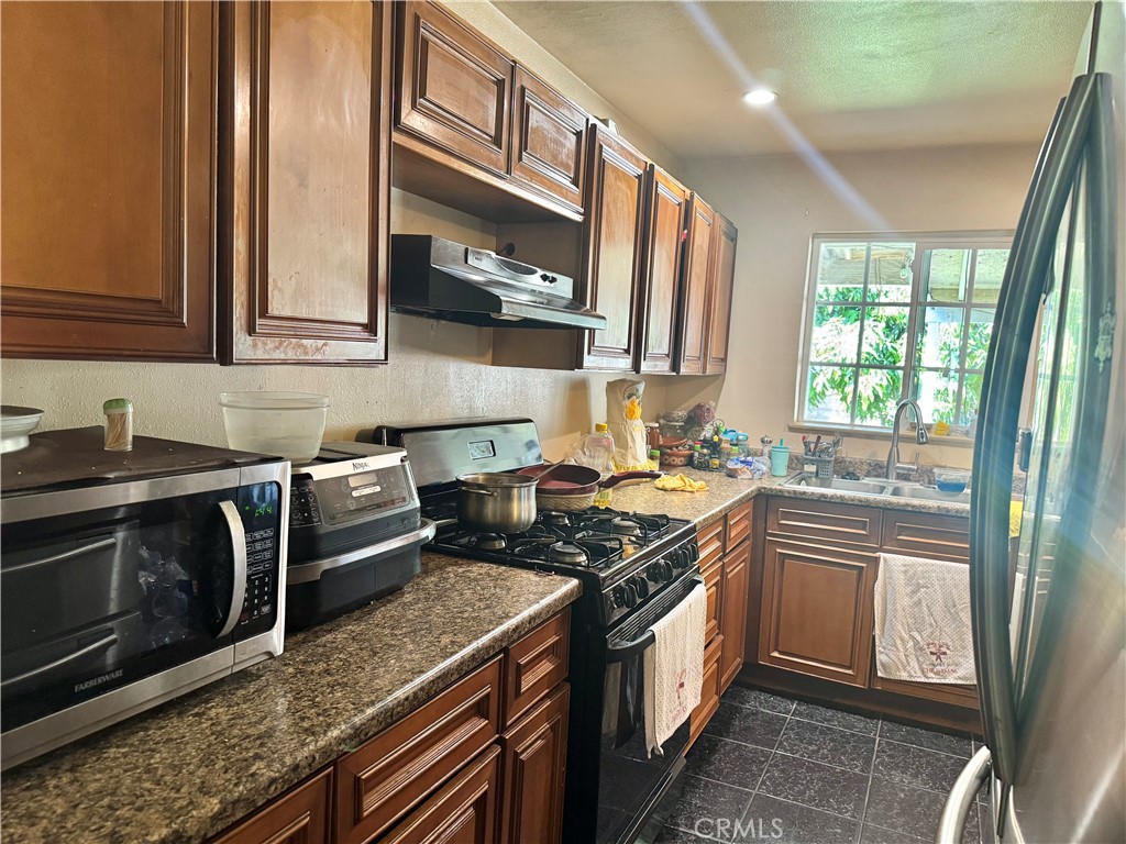 1042 North Alice Avenue Rialto, CA 92376 - Photo 11 of 31 a kitchen with stainless steel appliances granite countertop a stove a sink and a microwave