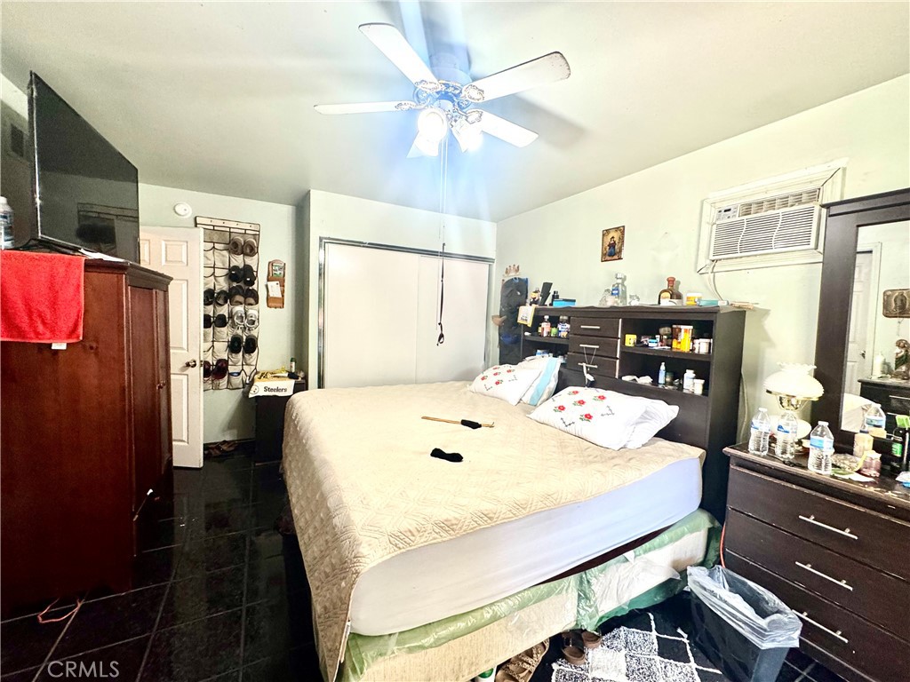 1042 North Alice Avenue Rialto, CA 92376 - Photo 14 of 31 a bed room with a bed mirror and a chandelier