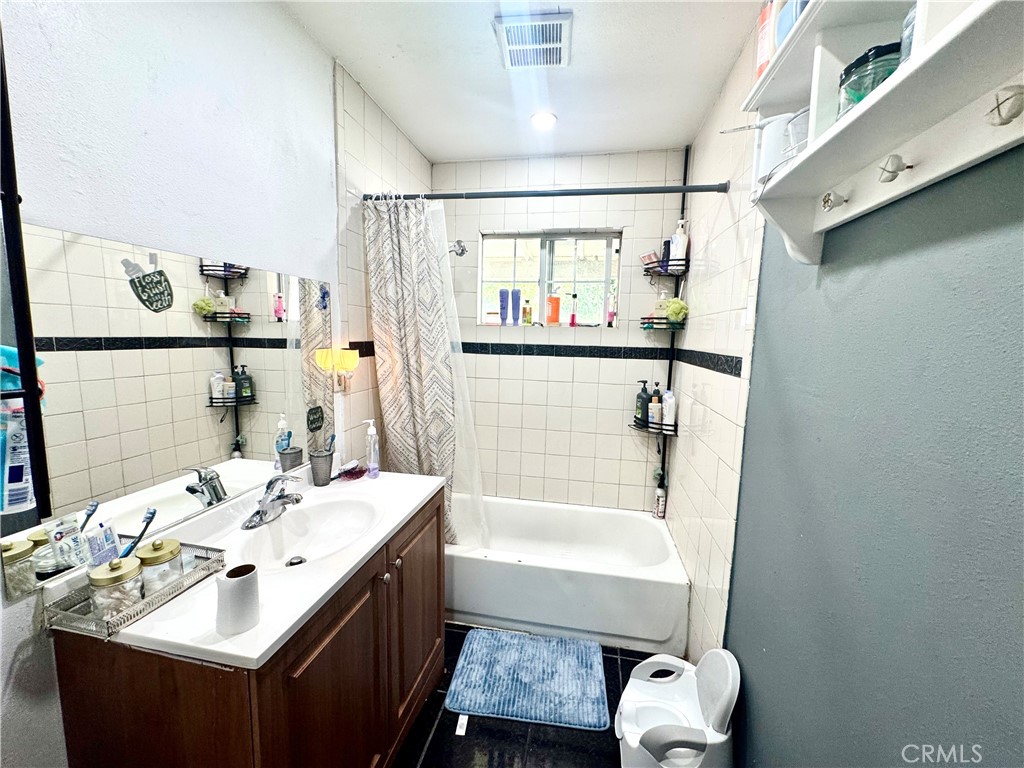 1042 North Alice Avenue Rialto, CA 92376 - Photo 17 of 31 a bathroom with a sink mirror and a bathtub